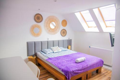 a bedroom with a bed with a purple blanket at Orle Gniazdo in Władysławowo