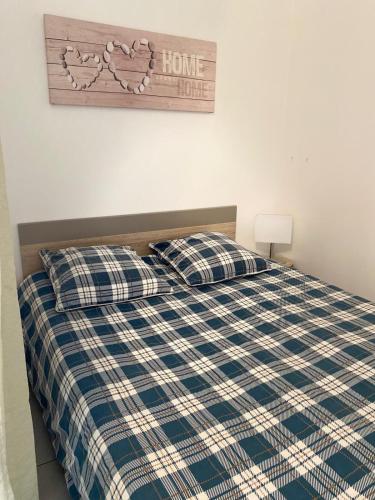 une chambre avec un lit avec une couverture à carreaux dans l'établissement Appartement aux portes de Paris, à Créteil
