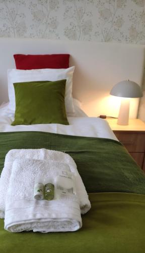 a bed with two towels and a book on it at Arianna Apartman in Miskolc