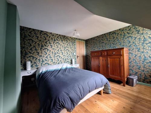 une chambre avec un lit et une commode dans l'établissement La maison de Carine et Didier, à Godewaersvelde