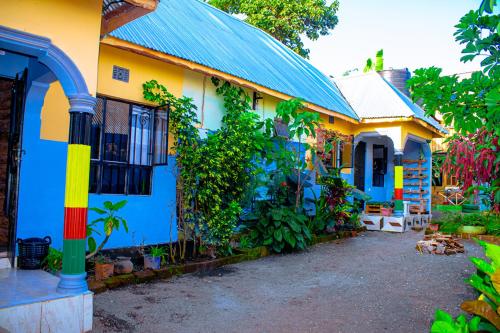 a yellow and blue house with a blue roof at Arusha Jua Eco Home- on coffee farm in Arusha