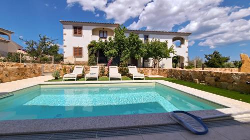 a swimming pool in front of a villa at La Casa di Emy in Budoni