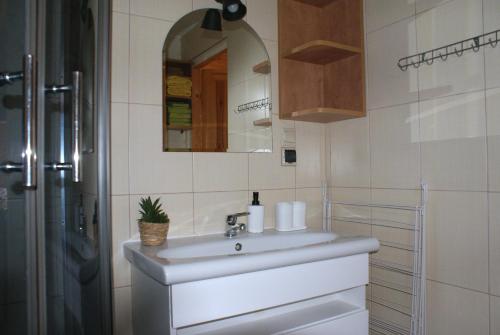 a bathroom with a white sink and a mirror at Mandarynka OW in Jarosławiec