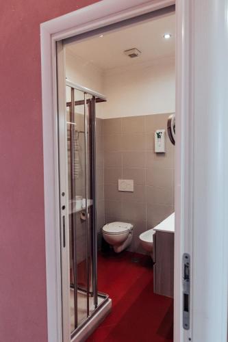 a bathroom with a toilet and a glass shower at Villa Erasi in Fiumicino