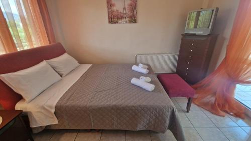 a bedroom with a bed and a chair and a television at Modern Sea Villa in Leptokaria in Leptokaria