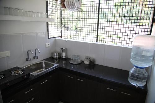 a kitchen with a sink and a bottle of water at Saaketh Holiday Home(2) in Kozhikode