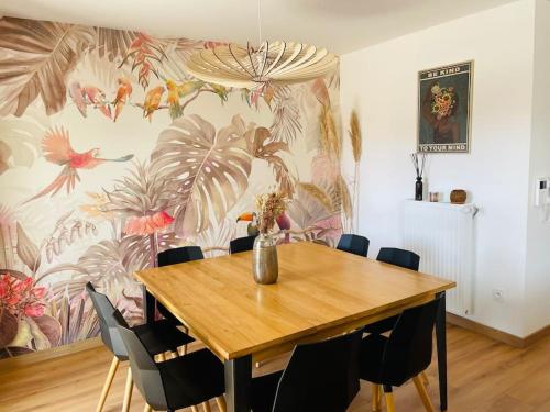 a dining room with a table with chairs and a wallpaper at Spacious Near Center Terrace et Parking in Rennes