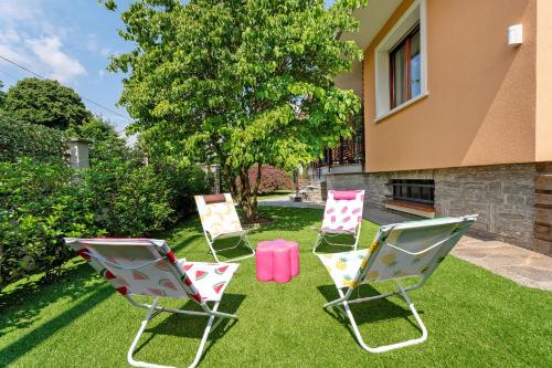 three lawn chairs and a table in a yard at La Casa Dei Girasoli-Lago Maggiore in Castelletto sopra Ticino