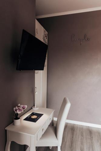 a white desk with a chair and a tv on a wall at Villa Erasi in Fiumicino
