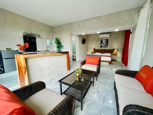 a living room with couches and tables and a kitchen at Villas Coco Mare in Acapulco