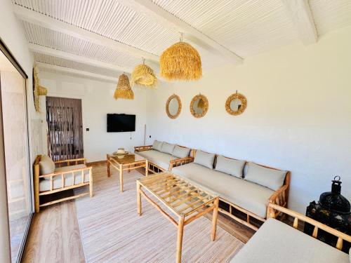 a living room with two couches and a tv at DAR MAÏSSA in Asilah