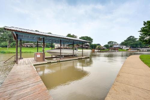 a dock with a boat on a river at Lakefront Gun Barrel City Home with Dock and Deck in Gun Barrel City