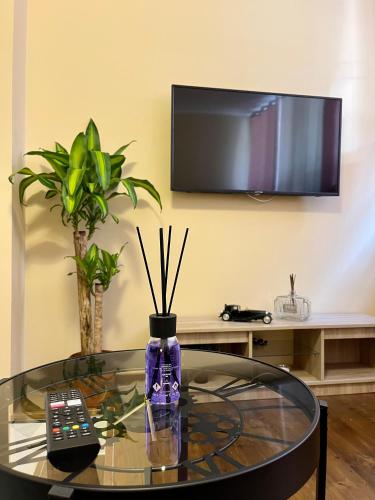 a glass table with a remote control and a tv at Dimora Chic - A 5 Fermate Dal Duomo in Milan