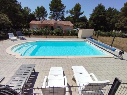 une piscine avec des chaises longues et une maison dans l'établissement Se ressourcer au calme, à Régusse