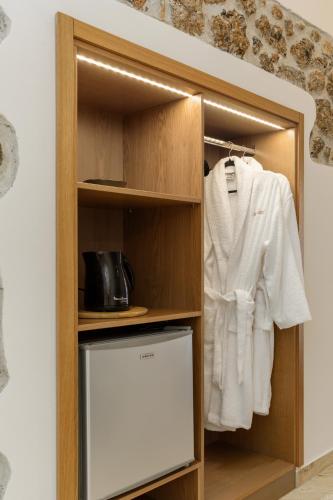 a closet with a white shirt and a refrigerator at Meydani Suites in Litochoro