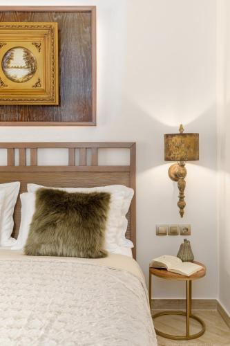 a bedroom with a bed with a wooden headboard and a table at Meydani Suites in Litochoro