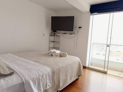 a bedroom with a bed and a flat screen tv at Apartamento moderno y céntrico en Lima, 3 Dormitorios in Lima