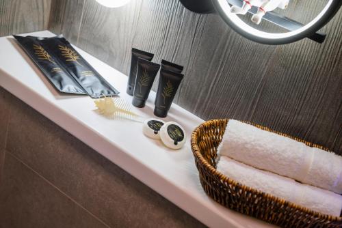 a bathroom shelf with a basket of towels and a mirror at Five Business-class rooms in R-house near Mega Center Almaty in Almaty