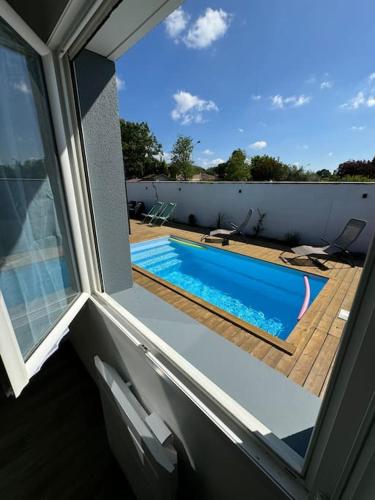 Elle offre une vue sur la piscine depuis sa fenêtre. dans l'établissement Confortable Maison Avenue du Cap Ferret, à Saint-Jean-dʼIllac