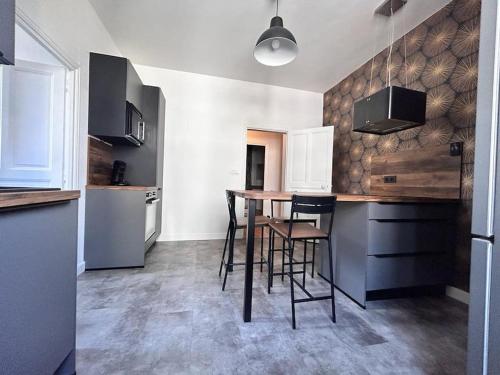 une cuisine avec une table et des chaises dans une pièce dans l'établissement Spacieux T4 avec grande cuisine Pradelle RDV, à Clermont-Ferrand