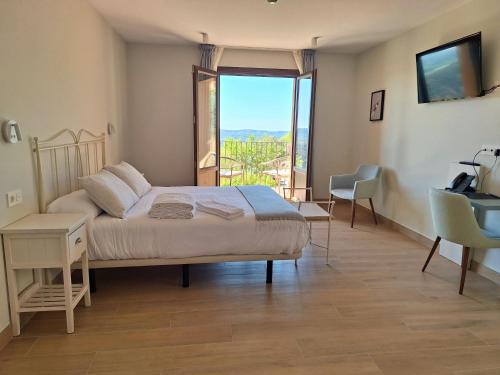 a bedroom with a bed and a large window at Hotel Vinoteca Alquezar - Adults Only - in Alquézar