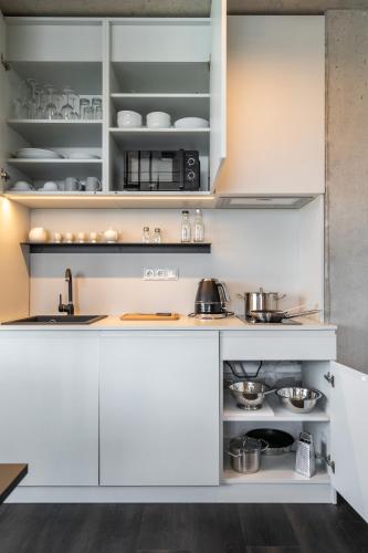 a kitchen with white cabinets and a sink at HONEST Ricany in Ricany
