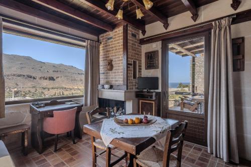 a dining room with a table with a bowl of fruit on it at Terra Minoika Boutique Resort in Káto Zákros