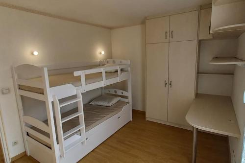 Cette petite chambre comprend 2 lits superposés et un bureau. dans l'établissement Appartement tout-terrain !, à Metz