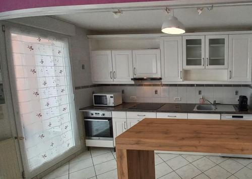 une cuisine avec des armoires blanches et un comptoir dans l'établissement Appartement tout-terrain !, à Metz