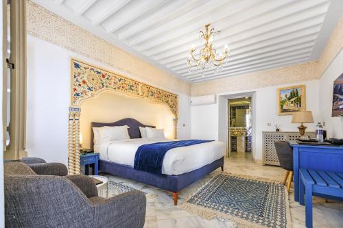 a bedroom with a large bed and two chairs at La Menara Hotel & SPA in Sidi Bou Saïd