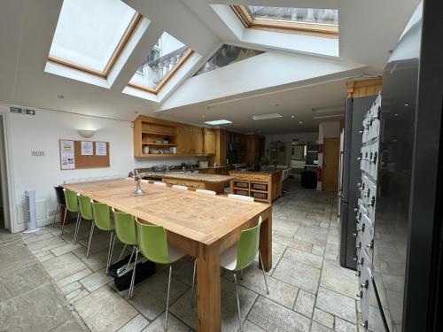 a kitchen with a wooden table and green chairs at 365 London Hostel in London
