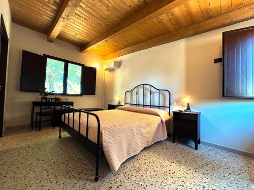 a bedroom with a bed and two tables and a window at Azienda Agrituristica Il Pago in Nova Siri Marina