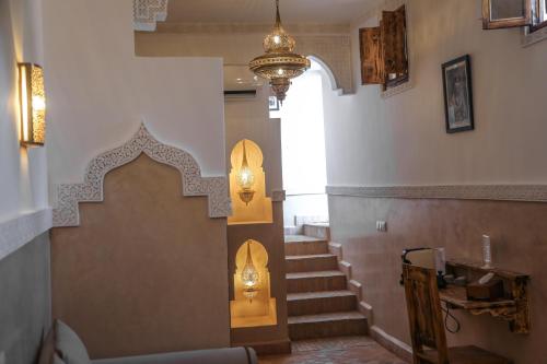 un escalier dans un bâtiment avec une lumière sur le mur dans l'établissement Riad Anya & SPA, à Marrakech