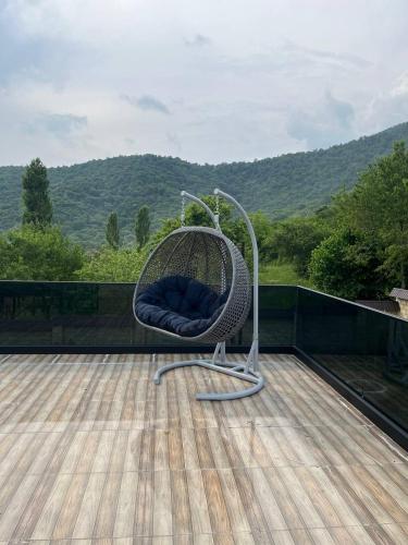 a wicker chair sitting on top of a deck at Qafqaz Mountain Terrace İndoor Hot Pool in Gabala