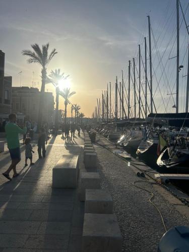 a group of people walking along a dock with boats at Dimora del Sole in Brindisi