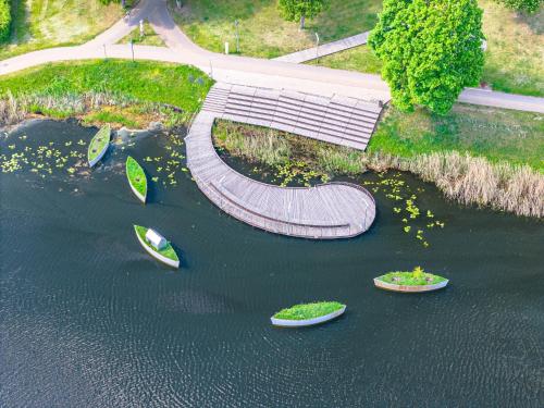 a walkway in the middle of a body of water at Molėtai Hotel in Molėtai