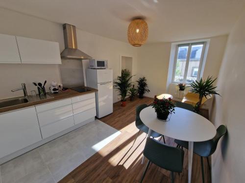 une cuisine et une salle à manger avec une table et des chaises dans l'établissement Superbe Appartement très lumineux, à Concarneau