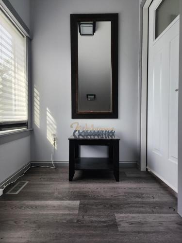 a mirror on a wall with a table in a room at Loft with Patio & Hot tub in Lethbridge