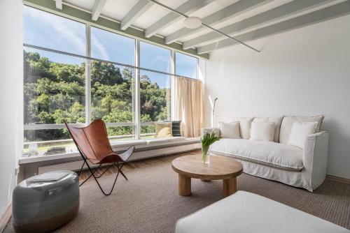 a living room with a white couch and a table at Casas do Sarela by Upper Luxury Housing in Santiago de Compostela