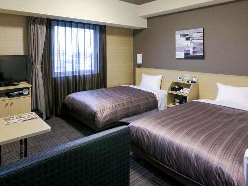Tempat tidur dalam kamar di Hotel Route Inn Hamamatsu Dealer Dori