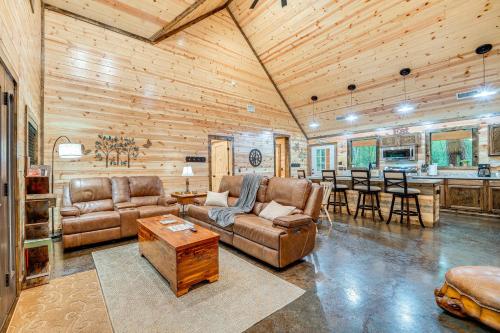a living room with leather furniture and a kitchen at Near Choctaw Casino Broken Bow Cabin with Hot Tub! in Broken Bow