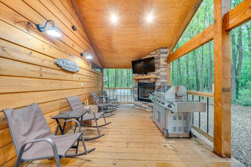 a screened in porch with chairs and a stove at Near Choctaw Casino Broken Bow Cabin with Hot Tub! in Broken Bow