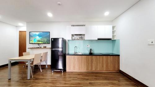 Una cocina con una mesa y un refrigerador de acero inoxidable. en GOLD VILLA Apartment, en Da Nang