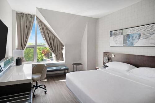 Habitación de hotel con cama, escritorio y ventana en Delta Hotels by Marriott Fredericton en Fredericton