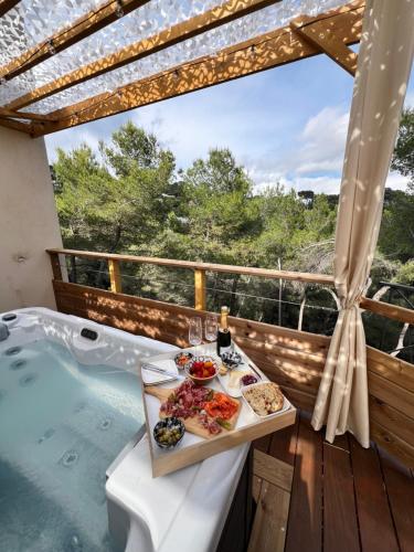 a tray of food sitting on a table next to a hot tub at LOVE ROOM Tente Lodge spa MFG chez C&C, exclusivement réservée aux ADULTES in Cantaron