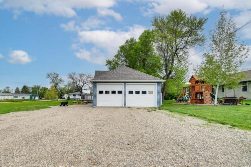 a driveway with a white garage and a house at Serene Devils Lake House with Deck and Fire Pit! in Devils Lake