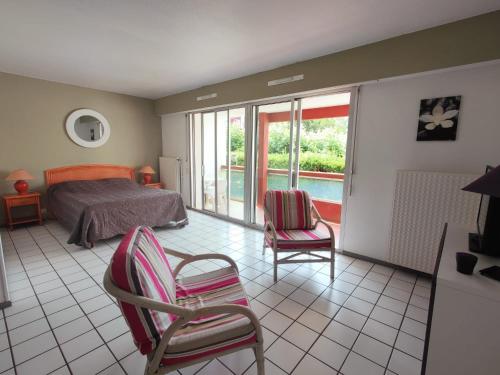 - une chambre avec un lit, des chaises et un balcon dans l'établissement Confortable Studio en Bord de Mer, à Anglet