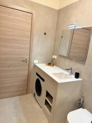 a bathroom with a washing machine and a sink at Giglio di Mare Apartments in Rossano