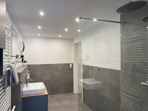 a bathroom with two sinks and a glass shower at Ferienresidenz Villa Augusta in Bad Salzuflen
