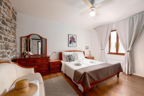 a bedroom with a bed and a mirror and a chair at Vila Astra in Matulji